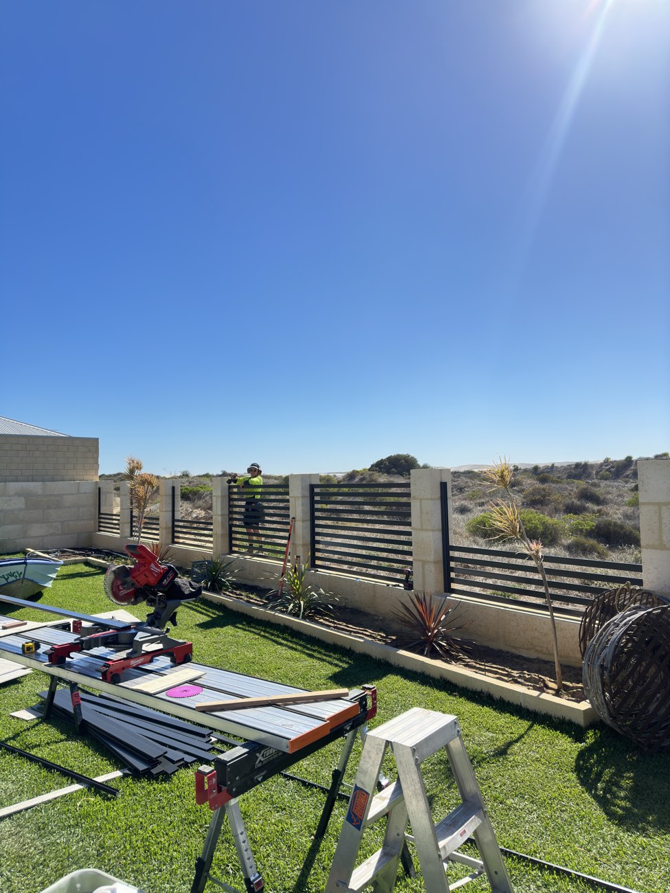 Aluminium slat fencing between limestone piers on a coastal Perth property