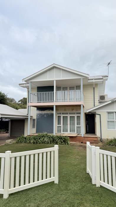 Two-storey deck frame with a roof frame scotched into an existing house